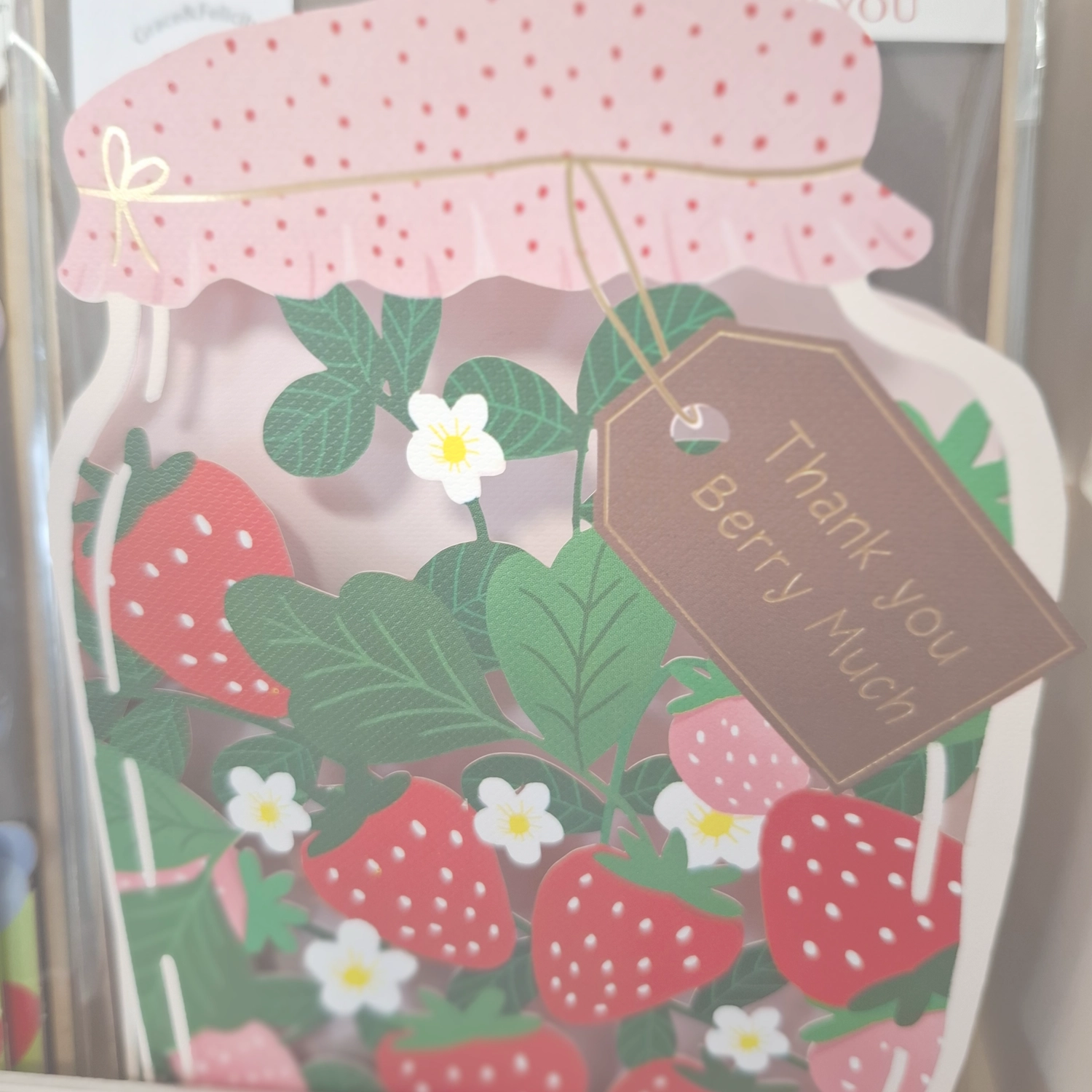 Grace&Felicity - concept store - Eine bezaubernde Grußkarte mit Erdbeermotiv in Form eines Marmeladenglases mit einem Anhänger, auf dem „Thank You Berry Much“ steht.